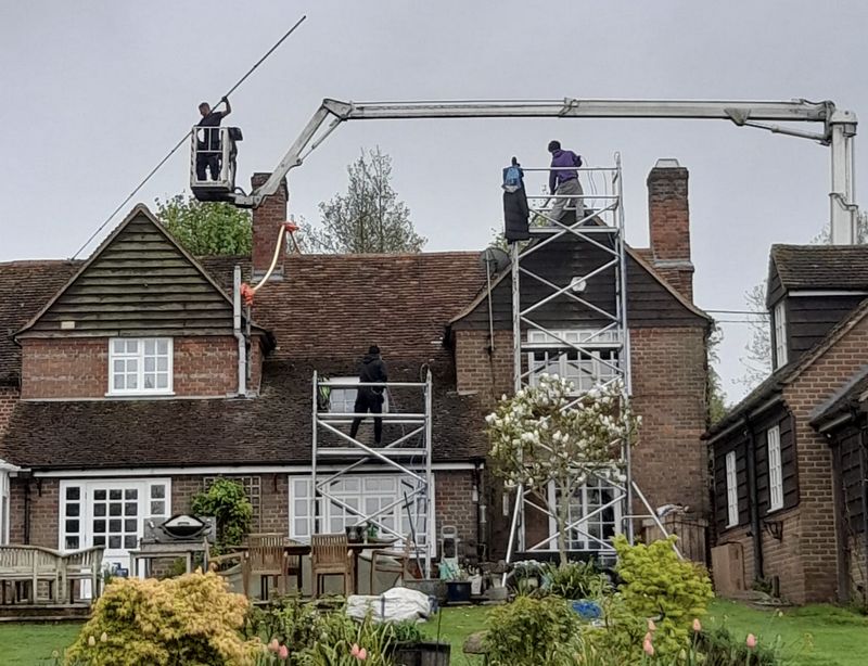 The Moss Cleaners using cherry picker and scaffolding to clean roof safely and professionally in New Milton, Hampshire